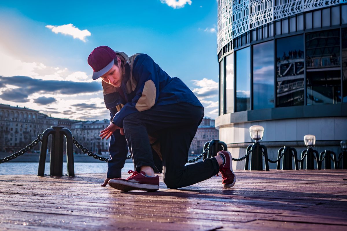 A young man skateboarding while wearing streetwear, including a graphic tee and sneakers, showcasing the connection between streetwear and street culture