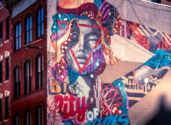 a wall with graffiti about a woman with symbols